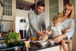 © luckybusiness - Happy family in kitchen making breakfast