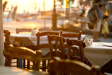 Abendstimmung Im Restaurant Am Meer, Blick In Die Untergehende Sonne , Stühle Und Tische Am Hafen