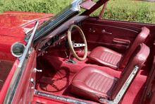 Interior View With Instruments And Wooden Steering Wheel Of An Old Red Cabriolet
