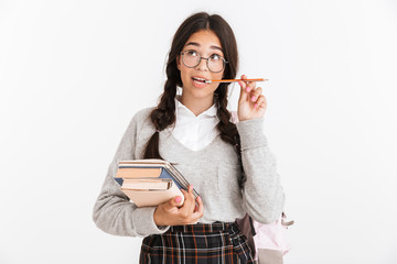 Wall Mural - Photo closeup of young teenage girl wearing eyeglasses thinking while holding studying books and pen