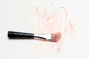 Wall Mural - Make up brush on white surface, cosmetic makeup powder exploding as it impacts table