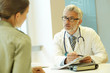© goodluz - Mature doctor talking to patient in modern clinic