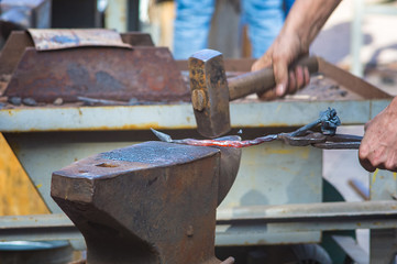 Wall Mural - blacksmith performs the forging of hot glowing metal on the anvil