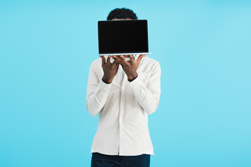 african american man showing laptop with blank screen isolated on blue