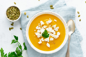 Wall Mural - Pumpkin cream soup with feta cheese, autumn homemade food, white background, top view