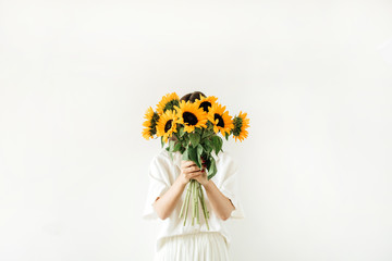 Young girl with sunflowers bouquet in hands on white background. Summer floral hero header composition.