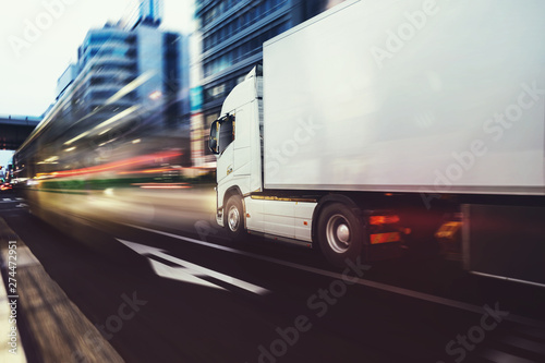 Fotografía White truck moving fast on the road in a modern city with light effect