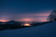 Ausblick auf Winterlandschaft mit Dorf bei Nacht von Hügel