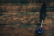 © Dmitriy - Quill pen and inkwell on a writer wooden desk background with copy space.