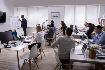 Wall Mural - An African Businessman Giving Presentation To His Colleagues