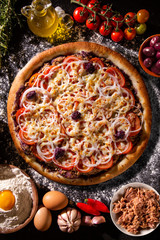 Wall Mural - Pizza tuna fish, onion, tomato and black olive on wood background. Top view, close up. Traditional Brazilian Pizza