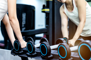 Concept of fitness.Woman exercising at the gym with dumbbell.Hands with dumbbells.