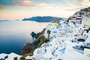 Wall Mural - beautiful Oia town on Santorini island, Greece. Traditional white architecture and greek orthodox churches with blue domes over the Caldera, Aegean sea. Scenic travel background