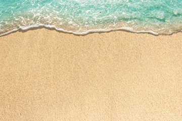 soft waves with foam of blue ocean on the sandy beach