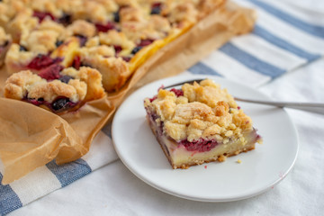 Wall Mural - crumble cake in a baking form and pieces of the cake on a table