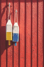 Fishing Buoys On Red Wooden Wall, Vertical