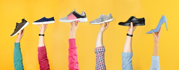 Wall Mural - Set of people holding different stylish shoes on color background, closeup