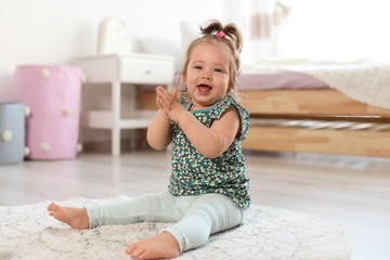 Poster - Adorable little baby girl sitting on floor in room