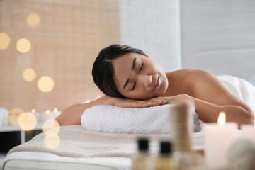 Wall Mural - Beautiful Asian woman lying on massage table in spa salon