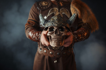 Wall Mural - Viking holds human skull in helmet