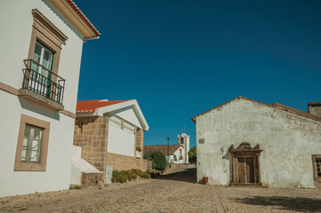 Whitewashed wall in old houses and entrance with stone door frame