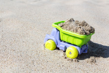 Children's Toy Truck With Sand. Concept Of Transportation Of Goods And Building Materials.