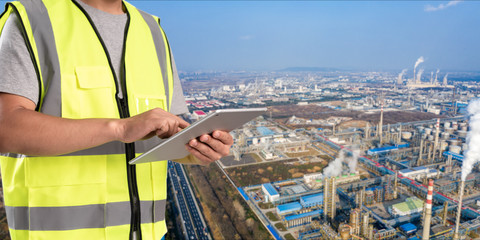 Wall Mural - worker working on pad with oil and gas refinery background,Smart factory concept.