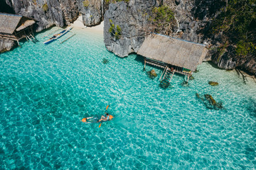 Man kayaking in the twin lagoon between the rocks and fishermen houses, enjoying the landscape. Concept about travels in the philippines