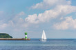 Leuchtturm und Segelboot vor Lübeck Travemünde bei strahlendem Sonnenschei, blauem Himmel