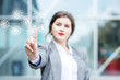 © Olha Tsiplyar - Beautiful Woman Pointing at Glowing Icon. Concept business, online commerce, technology and the Internet.