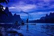 © Chanwit - Cormorant fisherman in Traditional showing of his birds on Li river near Xingping, Guangxi province, China.