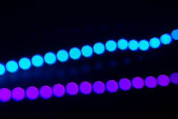 Two duotone neon lines of bokeh lights on black. Abstract background for your design