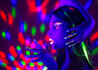 Wall Mural - Fashion disco woman. Dancing model in neon light, portrait of beauty girl with fluorescent makeup. Art design 