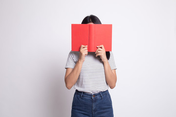 Young Asian woman with a book cover her face.