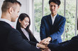 © khwanchai - Business teamwork, group of people put hand up together to make power in office