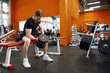 © olgasparrow - Young, athletic guy lifting dumbbells in the gym.