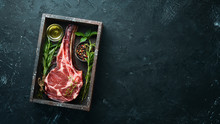 Raw Dry Steak Tomahawk On A Black Background. Steak Cowboy. Barbecue. Top View. Free Space For Text.