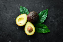 Fresh Avocado With Leaves On A Black Background. Top View. Free Space For Your Text.