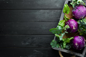 Wall Mural - Purple kohlrabi cabbage. On a black background. Top view. Free space for your text.