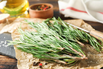 Poster - Composition with rosemary, oil, pepper, garlic and knife on wooden table, space for text