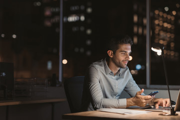 Young businessman working overtime at his office desk