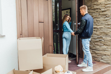 Attractive  married couple move to new house, going to enter a new home and life..