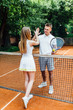 © Тарас Нагирняк - Young couple on tennis court. Handsome man and attractive woman give five, before are playing tennis.
