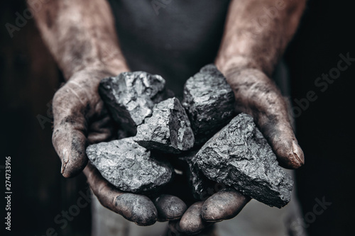 Fotografía Miner holds coal palm. Concept mining. Top view.
