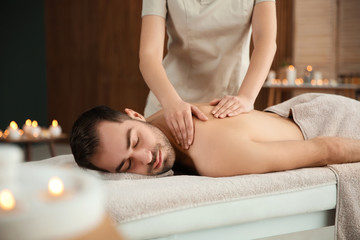 Sticker - Handsome man receiving back massage in spa salon