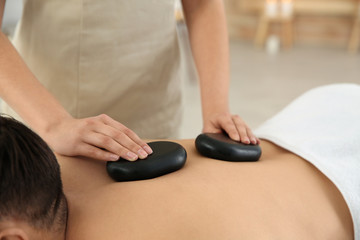 Sticker - Man receiving hot stone massage in spa salon, closeup