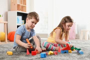 Wall Mural - Little children playing with colorful blocks indoors