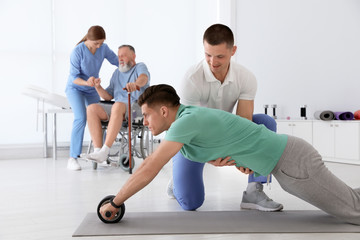 Wall Mural - Professional physiotherapists working with patients in rehabilitation center