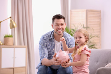 Poster - Family with piggy bank and money at home