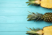 Fresh Whole And Cut Pineapples On Light Blue Wooden Background, Top View. Space For Text